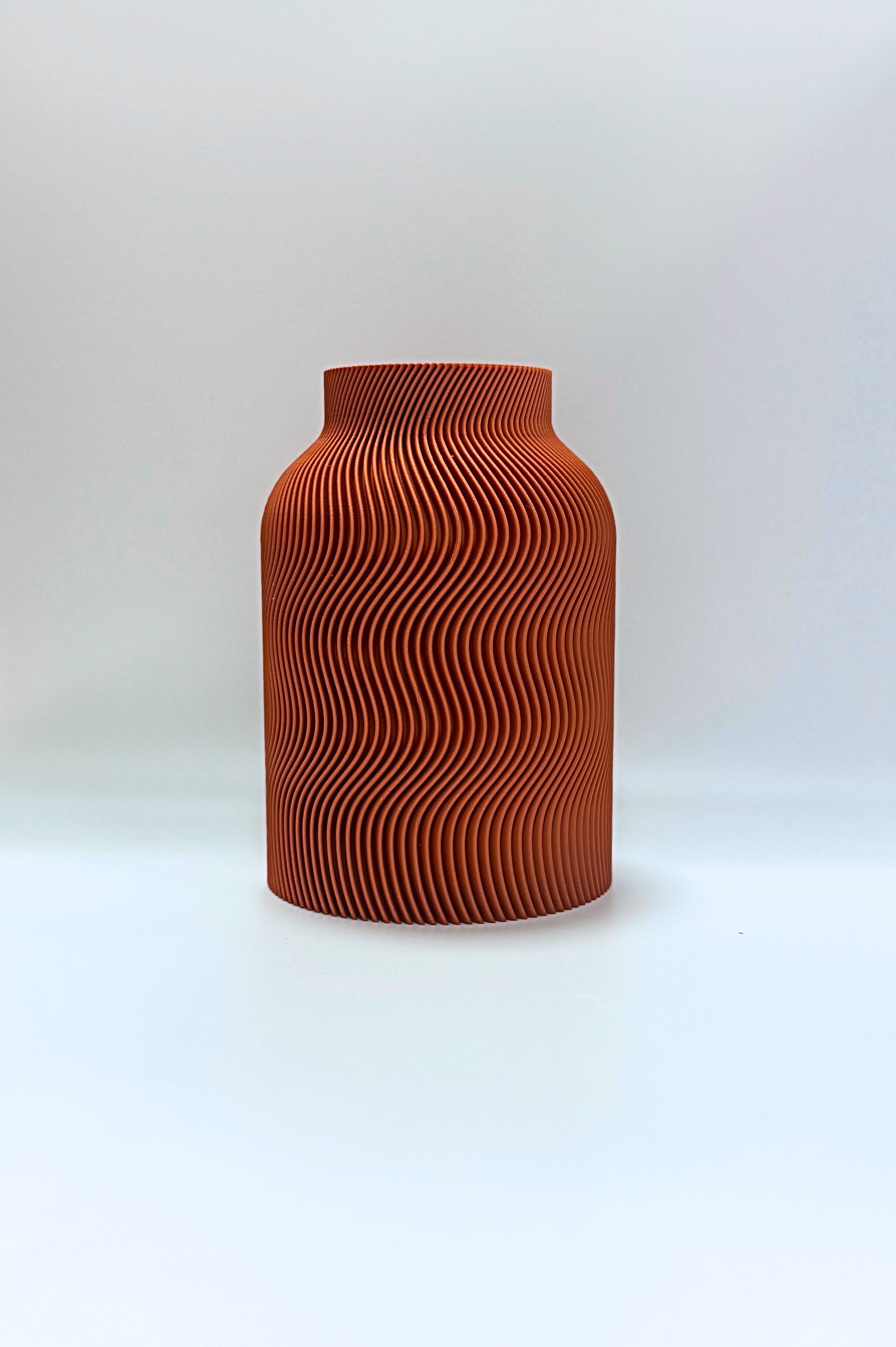Luna Vase in Terra Cotta color, featuring elegant curved wave patterns and included glass insert