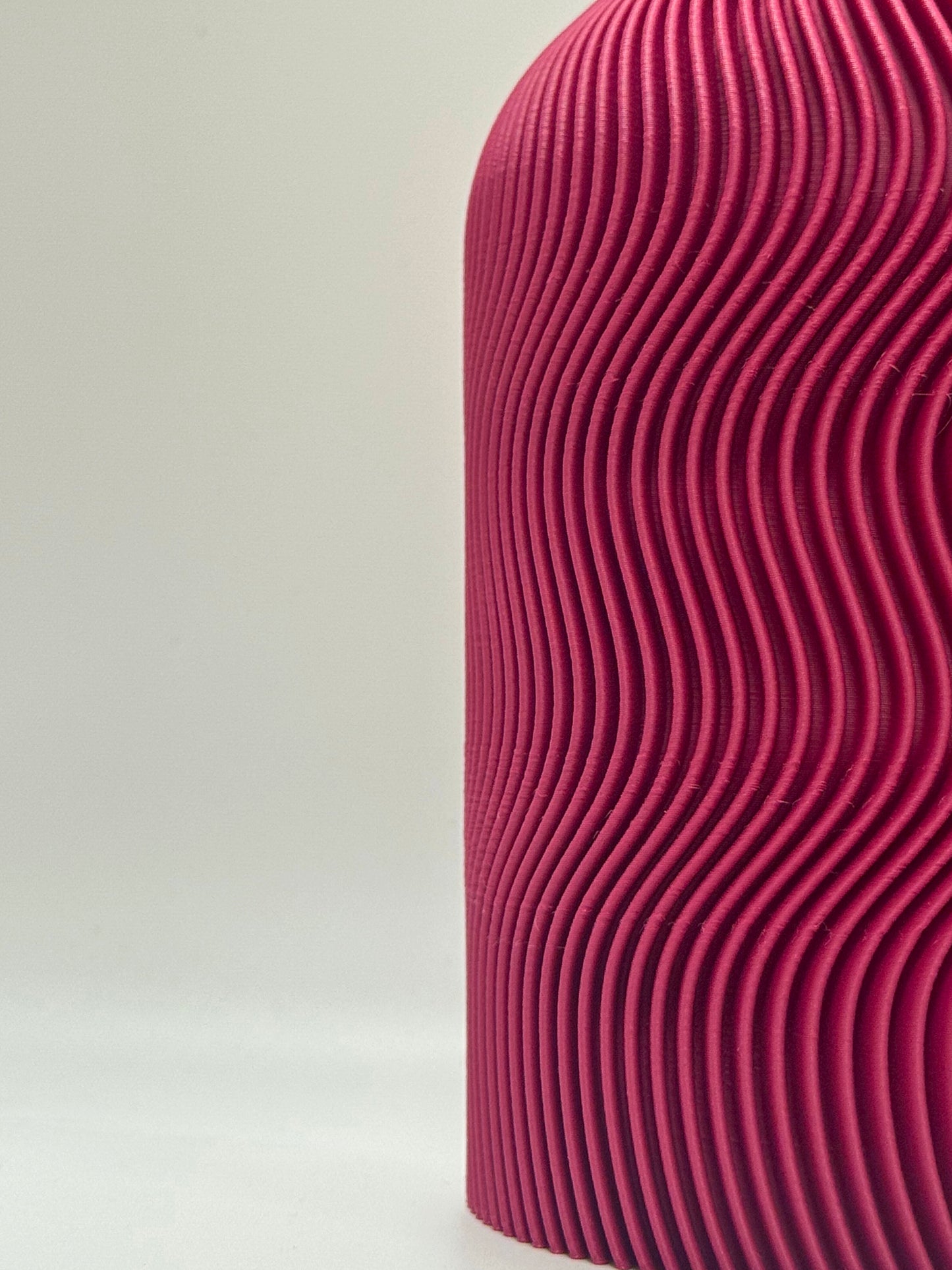 Close-up of a textured plum vase on a light gray background