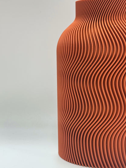Luna Vase in Terra Cotta color, featuring elegant curved wave patterns and included glass insert